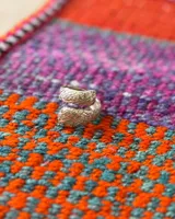 Anillo dorado con diseño de serpiente enroscada.