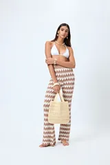 Pantalón tejido con motivo zigzag en tonos beige y blanco, de corte flare y cintura elastizada.