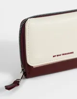 Billetera colorblock de cuerina con solapa con broche a presión, cierre y tirador.