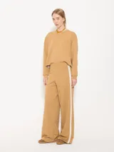 Buzo de punto color crema con lurex y mangas largas con puños ajustados.