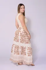 Falda larga color crema con estampado floral en verde oliva, cintura elastizada tipo smock y cordón ajustable con borlas.