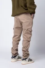 Pantalón cargo color beige con bolsillos laterales con solapa y botón. Corte ajustado.