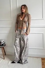 Pantalón baggy gris con estampado abstracto en tonos beige y blanco.