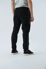 Pantalón de jogging gris oscuro de felpa con puños, cintura ajustable con cordón y logo estampado en la pierna.