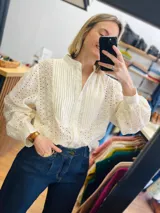 Camisa color manteca con bordado tipo borderie, cuello mao, cierre frontal con botones, mangas largas abuchonadas y puños abotonados.