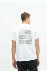 Remera blanca de algodón con estampado de recuadros con motivos botánicos en tonos grises y beige en la espalda.