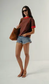 Camiseta de manga corta con cuello redondo y puños en contraste, de tejido a rayas horizontales blancas y verde oscuro. Presenta un pequeño logo bordado en el pecho.