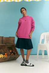 Buzo fucsia de corte holgado, cuello redondo y manga larga.