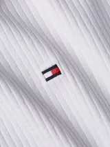 Remera blanca de manga larga con textura acanalada y logo de Tommy Hilfiger bordado en el pecho.