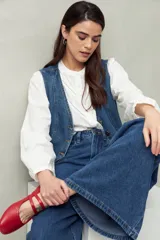 Pantalón de jean negro de calce ultra wide leg, tiro alto y silueta amplia desde la cadera hasta el bajo. Diseño clásico de cinco bolsillos y cierre con botón metálico y cremallera.