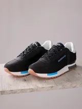 Championes urbanos negros con detalles en azul y suela color caramelo.