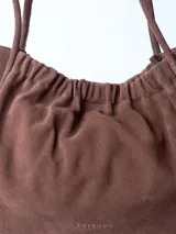 Bolso totebag negro de cuero con fruncido superior y doble asa fina.