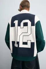 Polo de manga larga con corte relaxed fit, confeccionado en tejido con algodón. Presenta un diseño color block en azul marino, blanco y verde, con cuello solapa con cierre frontal de botonadura. Cuenta con bordados y parches combinados a contraste en delantero y espalda, y acabados en rib.
