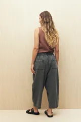 Pantalón gris oscuro de denim con corte holgado, cintura elastizada con cordón y ruedo con dobladillo.