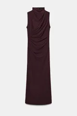 Vestido midi negro sin mangas, con cuello subido y detalle de drapeado en el delantero. Cierre en la espalda con cremallera oculta.