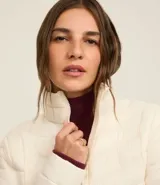 Campera puffer ultraligera color marrón, confeccionada en poliamida acolchada, con cuello alto y cierre por cremallera. Incluye bolsita con cordón.