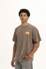 Remera color crudo de corte holgado con estampado pequeño en el pecho.