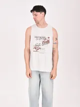 Musculosa blanca de algodón con estampado de un esqueleto surfeando en la playa.