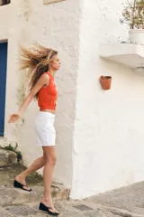 Top chaleco de punto color naranja con patrón de rombos en tonos naranja, blanco y marrón. Tiene cuello redondo y sisa.