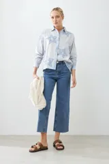 Camisa celeste con bordado de estrellas azules, de manga larga y corte clásico.
