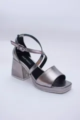 Sandalias de cuero color cobre con plataforma y taco cuadrado. Tiras cruzadas sobre el empeine y pulsera con hebilla al tobillo.