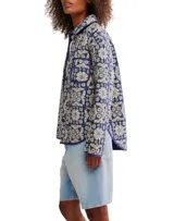 Chaqueta acolchada con estampado floral en tonos azul y beige, cuello camisero y cierre frontal con botones.