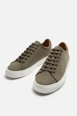 Zapatillas blancas de cuero sintético con cordones, forro interior y plantilla color beige.