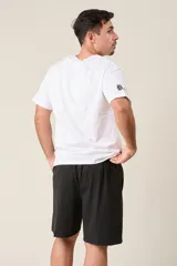 Bermuda deportiva de nylon color gris, de corte suelto, con cintura elástica y cordón de ajuste. Cuenta con detalles de líneas en los costados y bolsillos con cierre.