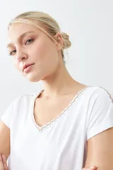 Remera blanca de algodón con escote en V y bordado en el borde. De corte recto y mangas cortas.
