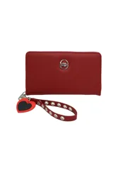 Billetera roja con cierre perimetral y logo metálico plateado de la marca en el frente. Incluye correa de muñeca con ojalillos metálicos y dije de corazón.