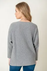 Sweater de lana color beige, de corte holgado y mangas largas.