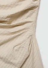 Minivestido strapless color beige con textura de rayas diagonales, diseño drapeado y cierre lateral invisible.