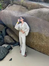 Pantalón de lino color beige, de calce amplio y tiro alto. Presenta abertura lateral en el ruedo.