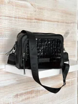 Bandolera negra de cuero genuino, con diseño moderno y práctica correa ajustable.