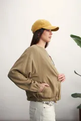 Chaqueta bomber negra con cierre frontal dorado y mangas largas con puños elásticos.