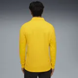 Camiseta de entrenamiento Puma color amarillo con cierre corto, escudo del Club Atlético Peñarol y logo de Puma estampados en negro.