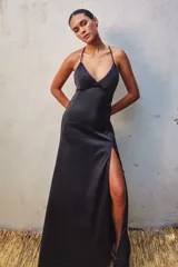 Vestido largo negro de satén con breteles finos, escote en V y tajo lateral alto.