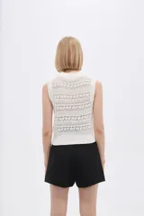 Top blanco calado sin mangas, de poliéster, al cuerpo y cuello redondo.