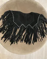 Chaleco negro de cuero vacuno con flecos y tachas plateadas.