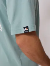 Remera negra de algodón con estampado en la espalda con el logo de Rusty Surf Company en forma de sol con motivos tribales en colores pastel.