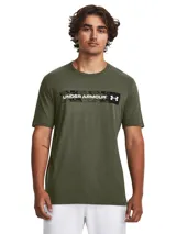 Remera verde militar de hombre Under Armour, de corte clásico y mangas cortas. Presenta una banda horizontal con estampado de camuflaje en el pecho, con el logo y nombre de la marca en color negro.
