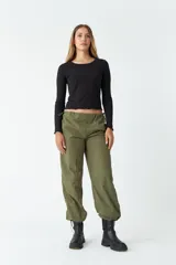 Pantalón negro de tiro medio, corte recto cropped y bolsillos laterales.