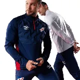 Buzo de entrenamiento azul marino con cierre parcial rojo, escudo del Club Nacional de Football y logo de Umbro en el pecho.