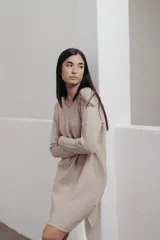 Vestido a la rodilla color bordó, tejido en punto suave, con escote en V, mangas largas y aberturas laterales.