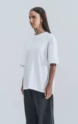 Remera blanca de algodón con corte crop, calce oversize, hombros caídos y cuello redondo.