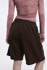 Short deportivo negro con cintura elástica y bolsillos laterales. Corte holgado a la rodilla.