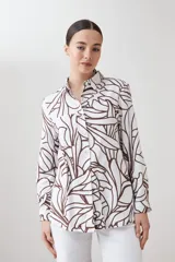 Camisa de lino color blanco con estampa abstracta color chocolate, de manga larga y cuello clásico.