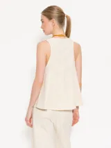 Musculosa color crema con escote con cordones cruzados.