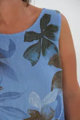 Vestido corto sin mangas, color celeste con estampado de flores marrones.