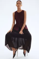 Pollera larga de gasa plisada color negro, de tiro alto con elástico fino en la cintura y bajo sobrehilado con vuelo. Forrada.